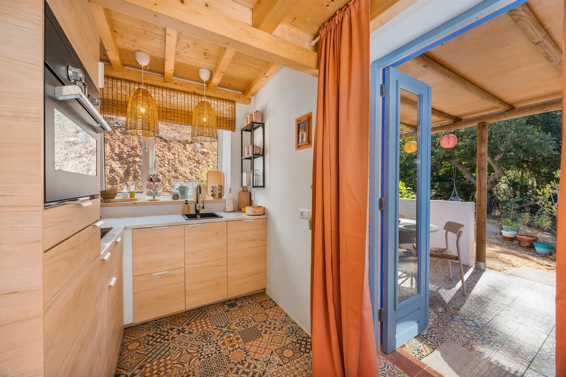 The kitchen with the terrace door open, looking out to the covered terrace.