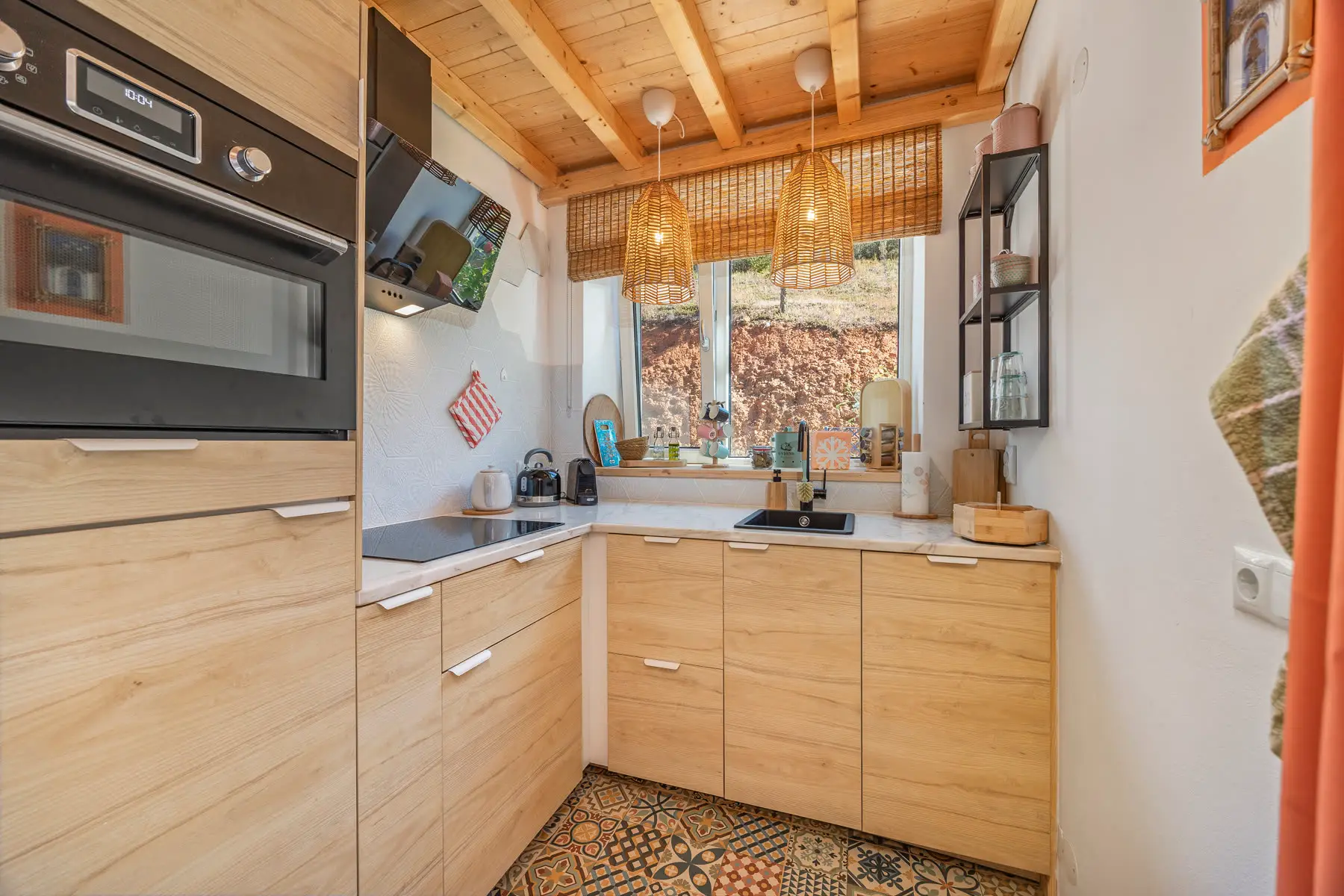 The kitchen in pale wood, looking out through the window.