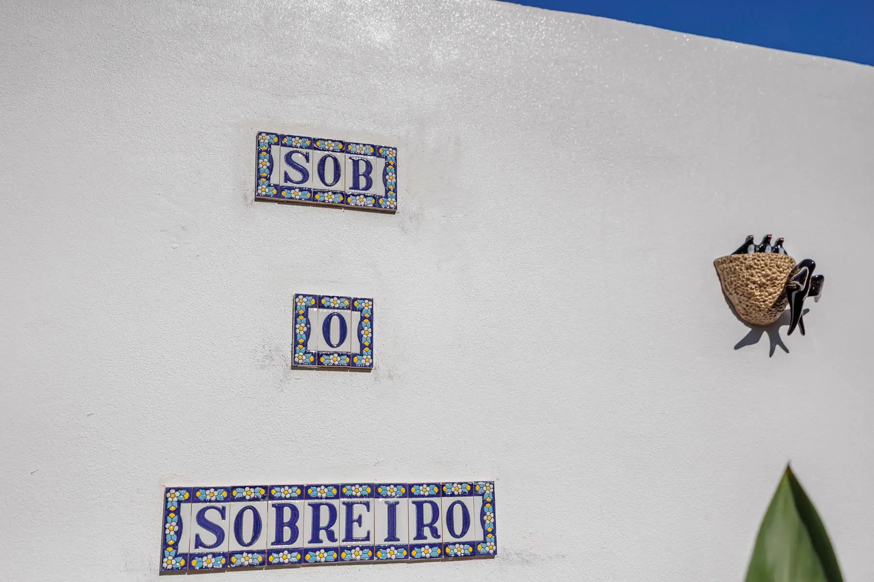The Sob o Sobreiro tiles on the white wall.